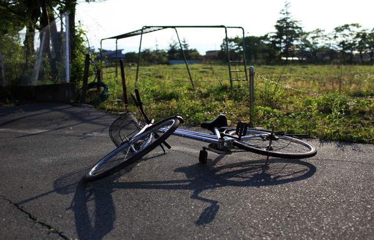 A bicycle lies abandoned at a local elementary school in Odaka.