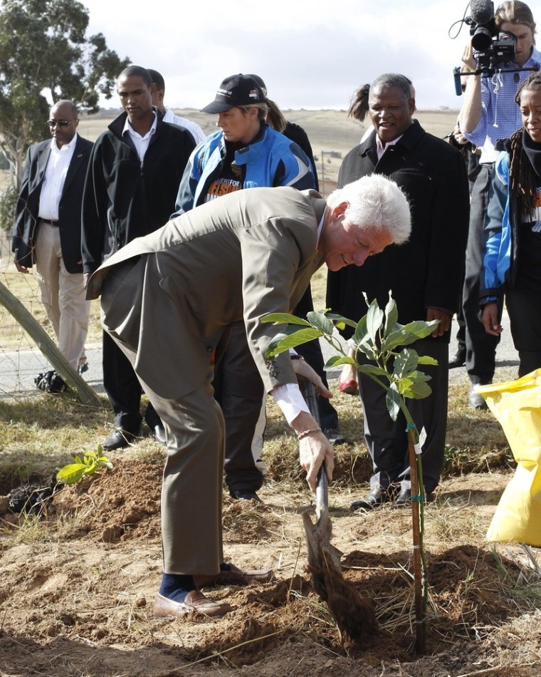 Former U.S. President Bill Clinton plants a tree in celebration of Mandela day in Qunu, July 17, 2012. Clinton also visited former South African President Nelson Mandela at his residence ahead of his 94th birthday celebrations.