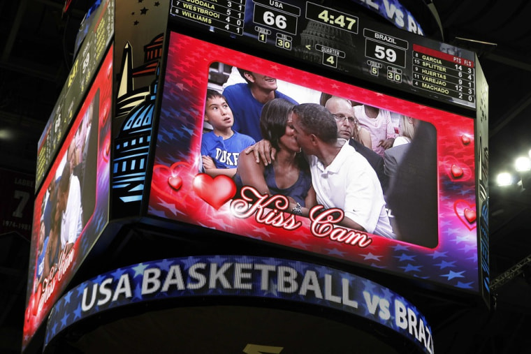 U.S. President Barack Obama and first lady Michelle Obama are shown kissing on the \"Kiss Cam\" screen during a timeout in the Olympic basketball exhibition game between the U.S. and Brazil national men's teams in Washington, July 16.