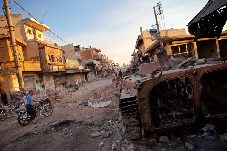 A destroyed Syrian forces tank stands in  street in Atareb in the province of Aleppo on Monday. Most of Atareb's residents  fled the town due to heavy fighting between Syrian forces and rebels.