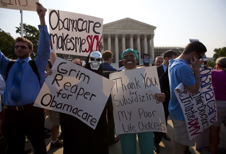 Demonstrators stand outside the Supreme Court in Washington, Thursday, June 28, 2012, before the court's ruling on health care.