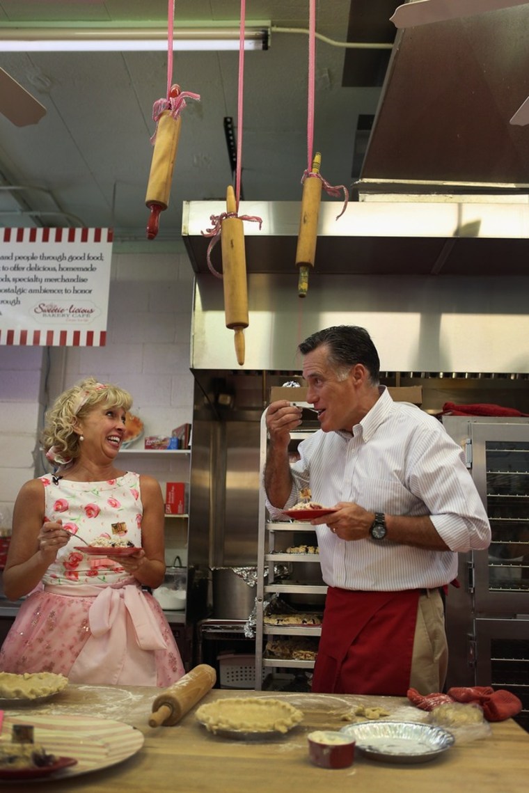 Republican presidential candidate, former Massachusetts Gov. Mitt Romney samples a cherry pie as Sweetie-licious Bakery Café store owner, Linda Hundt, looks on during a campaign stop at her store on June 19, 2012 in DeWitt, Michigan.
