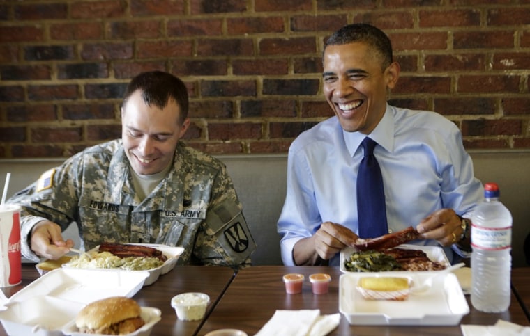President Obama eats ribs at Kenny's BBQ in Washington June 13, 2012. Seated beside Obama is U.S. Army 1st Lt. Bill Edwards, the 2012 Military Fatherhood Award winner.