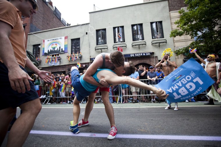 Revelers kiss in front of the Stonewall Inn during the New York City gay pride march. The annual civil rights demonstration commemorates the Stonewall riots of 1969, which erupted after a police raid on a gay bar, the Stonewall Inn on Christopher Street.