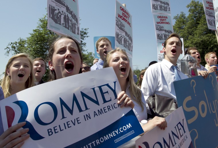 Supporters of Republican presidential candidate and former Massachusetts Gov. Mitt Romney chant slogans and display placards before a speech by Obama strategist David Axelrod in front of the Statehouse, in Boston, Thursday, May 31, 2012.