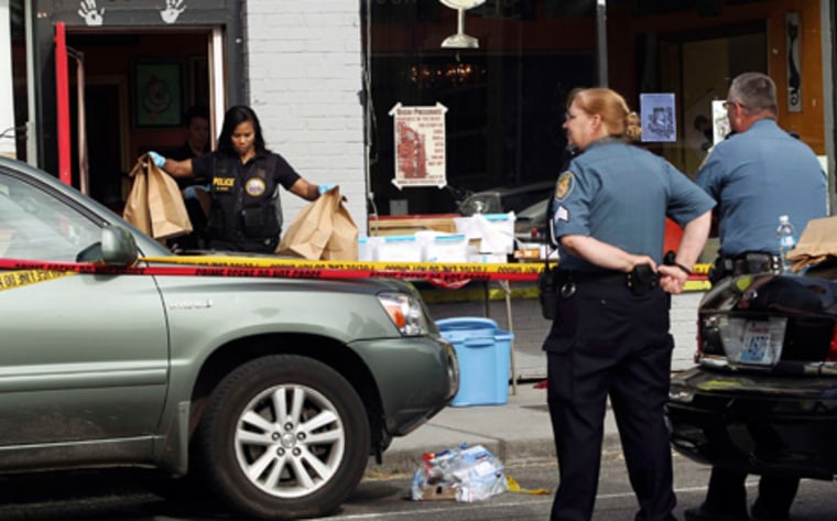 Crime scene investigators remove evidence from Cafe Racer in North Seattle while Seattle Police look on.