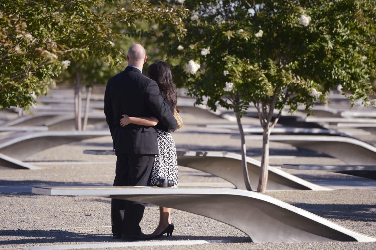 A couple stand near a memorial bench at the Pentagon 9/11 Memorial prior to the 11th Anniversary ceremony of the September 11, 2001 attacks at the Pentagon in Arlington, Virginia.