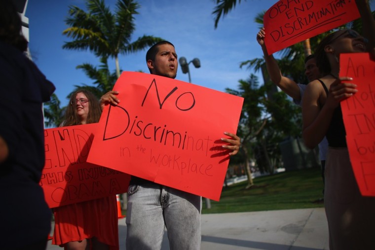 Protesters stand outside a fundraiser for President Obama in June in Florida to ask for an executive action on workplace discrimination for LGBT Americans.