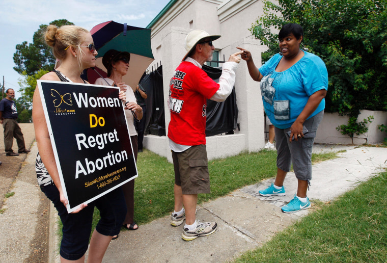 Anti-abortion demonstrators argue with an administrator from Mississippi's only abortion clinic today after the state's anti-abortion law was blocked by a federal judge late yesterday.