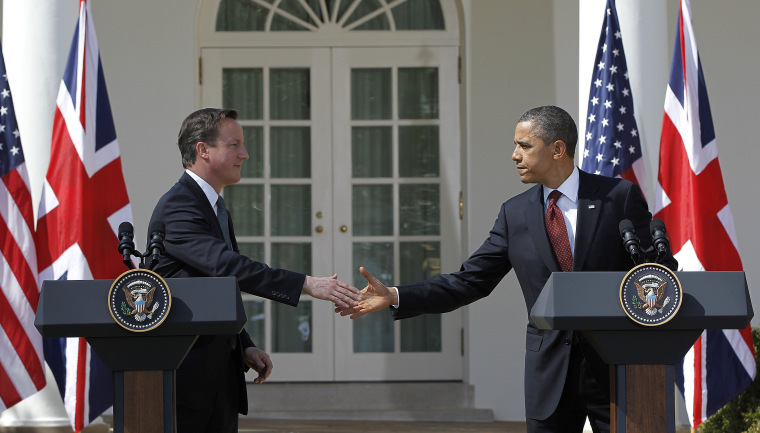 British Prime Minister David Cameron and President Barack Obama reach to shake hands during their joint news conference in the Rose Garden of the White House in Washington Wednesday, March 14, 2012