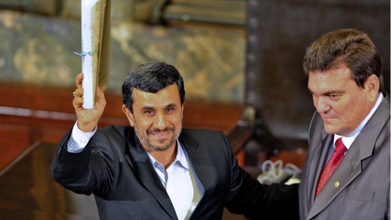 Iranian President Mahmoud Ahmadinejad (L) receives the Doctor Honoris Causa degree from the rector of Havana's University Gustavo Cobreiro, during a ceremony at the university in Havana, on January 11, 2012.