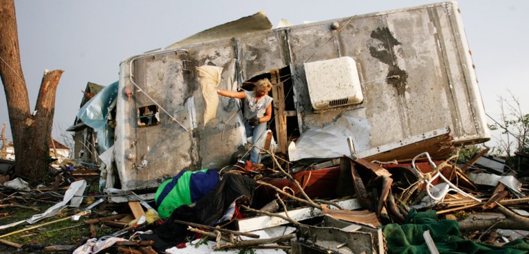 Julie Schmitt tosses out a pillow as she searches her boyfriend's trailer for his belongings after a devastating tornado hit Joplin, Missouri May 23, 2011.