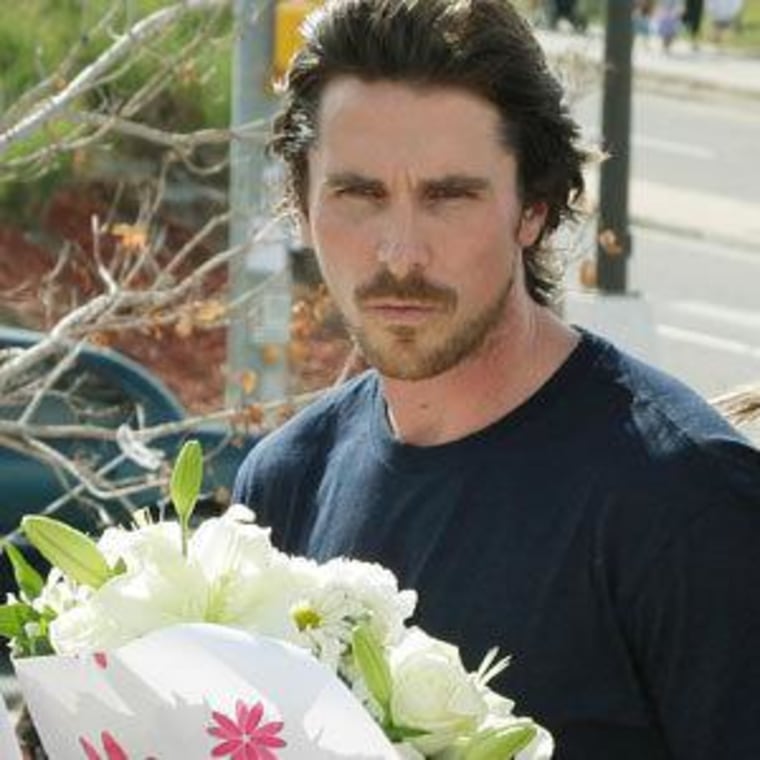 Actor Christian Bale with flowers as he visits a memorial in Aurora, Colorado on Tuesday.