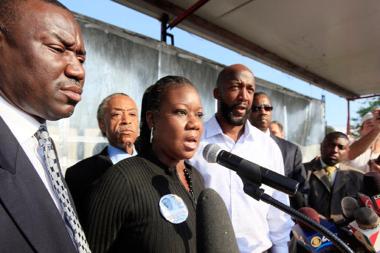 Family attorney Benjamin Crump and msnbc's Al Sharpton listening as Trayvon Martin's parents, Sybrina Fulton and Tracy Martin, speak before a rally in Sanford, Florida on Thursday.