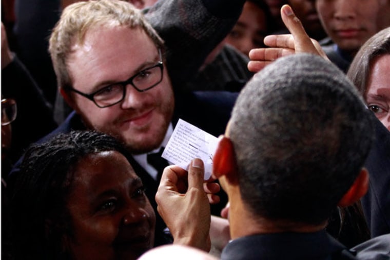 A OWS protester handing President Obama a note today in Manchester, New Hampshire.