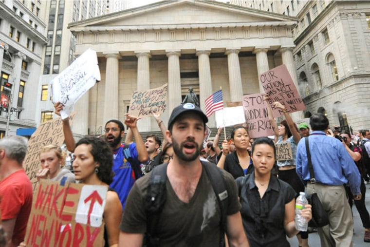 Wall Street protestors march past Federal Hall on Monday, September 26.