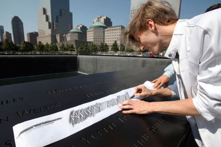 Malcolm DeCesare etching the name of victim Neal David Levin, the cousin of DeCesare's domestic partner, from one of the panels on Monday.