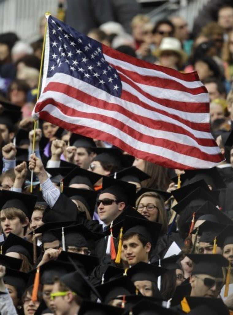 A graduate waves an American flag at the University of Michigan undergraduate commencement on April 30, 2011.
