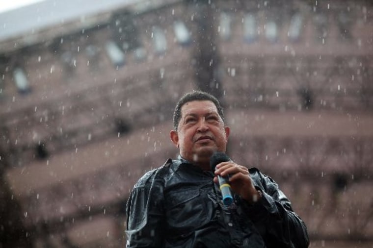 Under pouring rain, Venezuela's President Hugo Chavez holds a microphone during his closing campaign rally in Caracas, Venezuela, Thursday, Oct. 4, 2012. Chavez is running for re-election against opposition candidate Henrique Capriles in presidential...