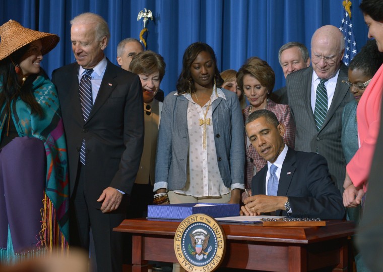 US President Barack Obama signs the Violence Against Women Act on March 7, 2013 in the Department of the Interior in Washington, DC as US Vice President Joe Biden (2nd-L), Sen. Patrick Leahy (R) D-VT,  Nancy Pelosi (Behind Obama)D-CA , members of...