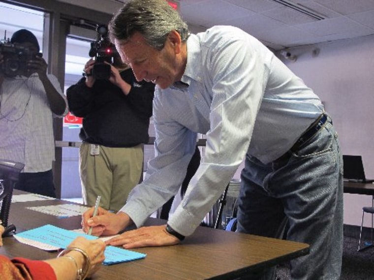 Former South Carolina Gov. Mark Sanford signs in before voting in Charleston, S.C., on Tuesday, April 2, 2013. (AP Photo/Bruce Smith)