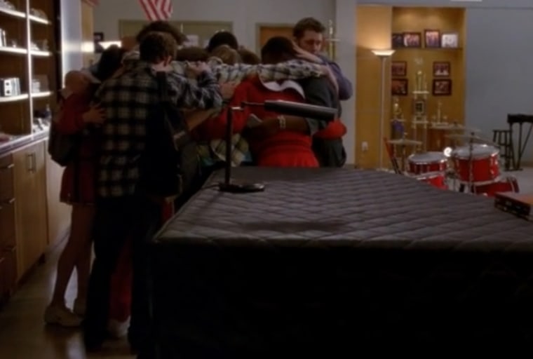 This screencap from the April 11, 2013 episode of \"Glee\" shows students hugging after gun shots were fired in their school.