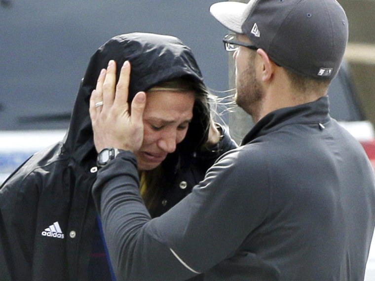 An unidentified Boston Marathon runner is comforted as she cries in the aftermath of two blasts which exploded near the finish line of the Boston Marathon in Boston. (Photo by Elise Amendola/AP Photo)