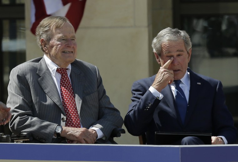 Former president George W. Bush wipes a tear after his speech during the dedication of the George W. Bush Presidential Center Thursday, April 25, 2013, in Dallas. Former president George H.W. Bush is at left. (AP Photo/David J. Phillip)