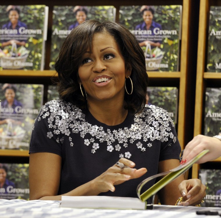 First lady Michelle Obama signs copies of her book \"American Grown: The Story of the White House Kitchen Garden and Garden Across America\" at the Politics &amp; Prose bookstore in Washington, Tuesday, May 7, 2013. (AP Photo/Susan Walsh)