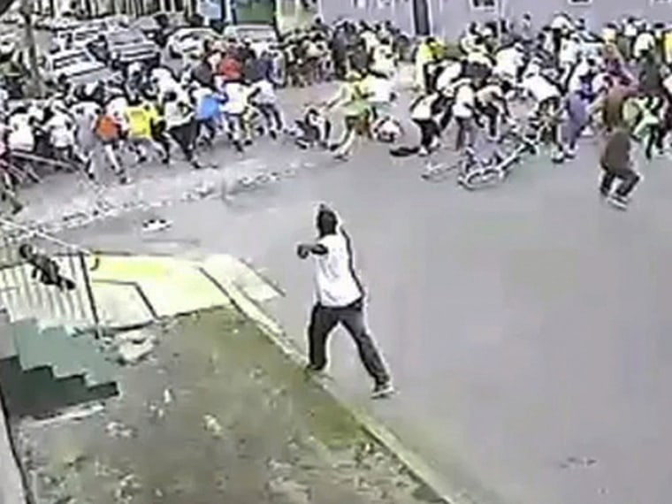 In this image taken from video and provided Monday, May 13, 2013, by the New Orleans Police Department, a possible shooting suspect in a white shirt, bottom center, shoots into a crowd of people, Sunday in New Orleans. (AP Photo/New Orleans Police...