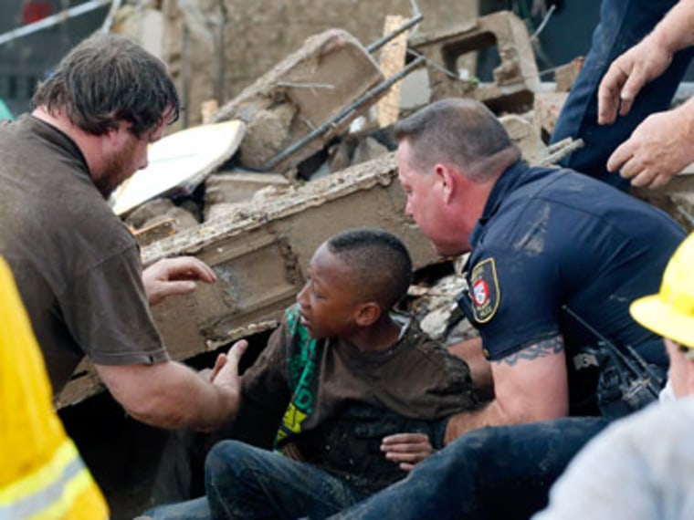 Rescue teams pull a boy from beneath a collapsed wall at the Plaza Towers Elementary School following a tornado in Moore, Okla., on May 20, 2013. (Photo by Sue Ogrocki/AP)