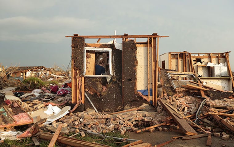 Dana Ulepich searches inside a room left standing at the back of her house destroyed after a powerful tornado ripped through the area on May 20, 2013 in Moore, Oklahoma. The tornado, reported to be at least EF4 strength and two miles wide, touched...