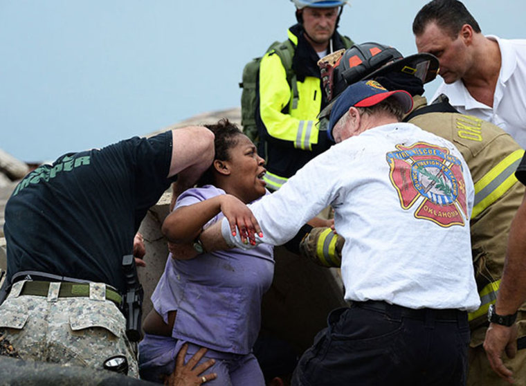 Rescue workers help free one of the 15 people that were trapped at a medical building at the Moore hospital complex after a tornado tore through the area of Moore, Oklahoma May 20, 2013. REUTERS/Gene Blevins  (UNITED STATES - Tags: ENVIRONMENT DISASTER...