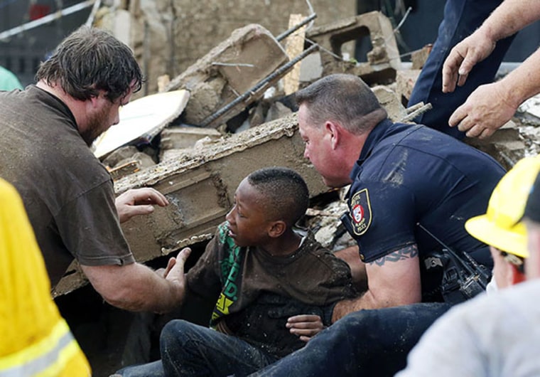 A boy is pulled from beneath a collapsed wall at the Plaza Towers Elementary School following a tornado in Moore, Okla., Monday, May 20, 2013. A tornado as much as a mile (1.6 kilometers) wide with winds up to 200 mph (320 kph) roared through the...