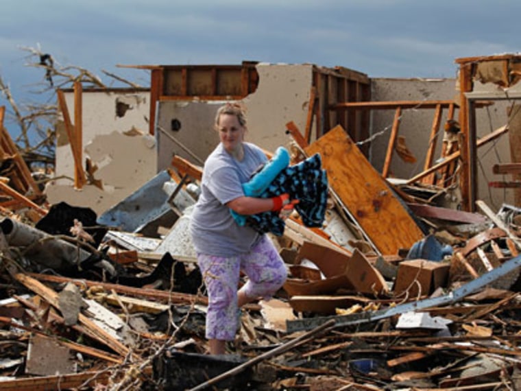 Kandi Scott salvages items from the rubble of her home in Moore, Oklahoma on May 21, 2013. (Photo by Brennan Linsley/AP)