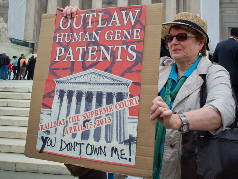 A woman holds a banner demanding a ban over human genes patents during a protest outside the US Supreme Court in Washington on April 15, 2013. The Supreme Court is poised to take up the highly charged question of whether human genes can be patented. ...