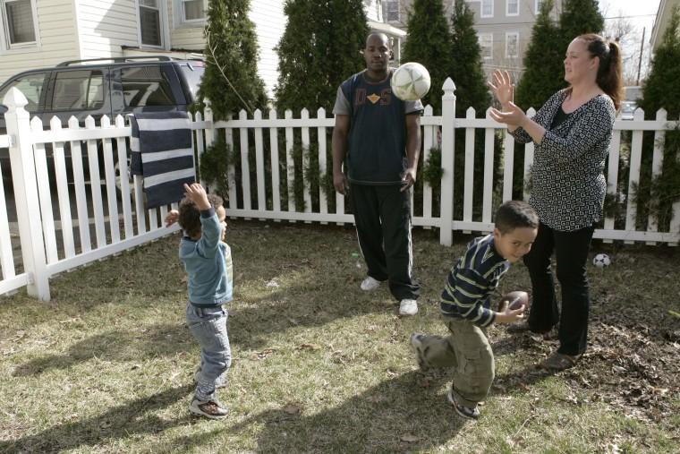 Michelle, right, and James Cadeau  with their children, Elliot, 2, left, and Justin, 5, play ball in the backyard of their home in West Orange, N.J., Friday, March 30, 2007. The surge of interracial marriages and multiracial children is producing a...