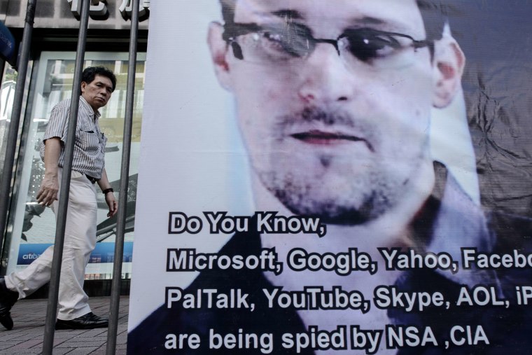 This picture taken on June 18, 2013 shows a man walking past a banner displayed in support of former National Security Agency contractor Edward Snowden in Hong Kong.  (AFP PHOTO / Philippe Lopez)