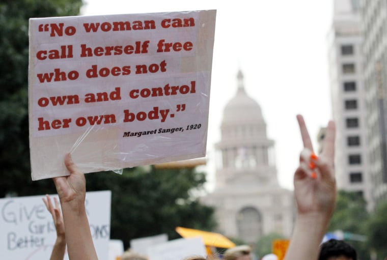 Protesters carry signs at an abortion rights march that originated at the State Capitol in Austin, Texas, July 8, 2013. The political battle in Texas over proposed restrictions on abortion resumes on Monday with a rally by abortion opponents and a...