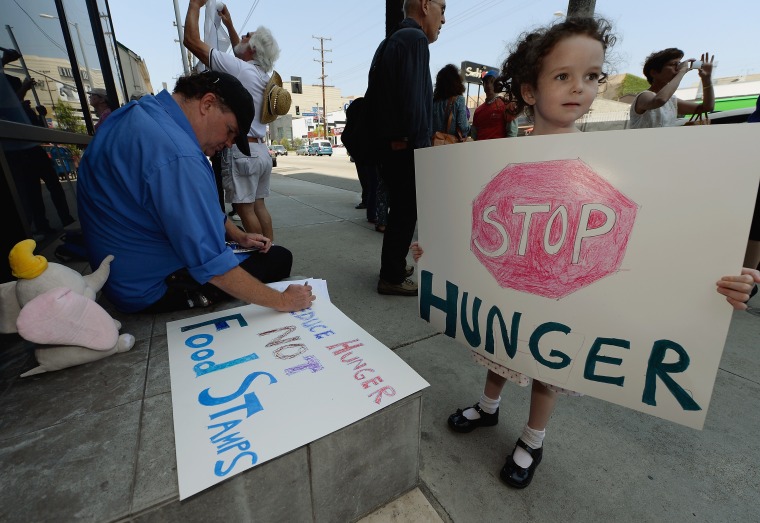 Gracie Shannon-Sanborn, 5, holds a sign as she joins her father Allen Sanborn (L) and members of Progressive Democrats of America and other activists as they hold a rally in front of Rep. Henry Waxman's office on June 17, 2013 in Los Angeles,...