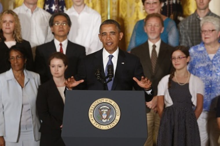 President Obama stands with families who benefited from the health care law provision that provides consumers with a refund if their insurance company doesn’t spend the majority of premium dollars on medical care as he  speaks about health care reform...