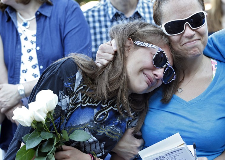 Jasmine Christman, left, is comforted by her mother Yulanda Vega Jordan during a memorial service for the victims of the Aurora theater shooting on the anniversary of the tragedy in Aurora, Colo., on Saturday, July 20, 2013. Jasmine lost a friend in...