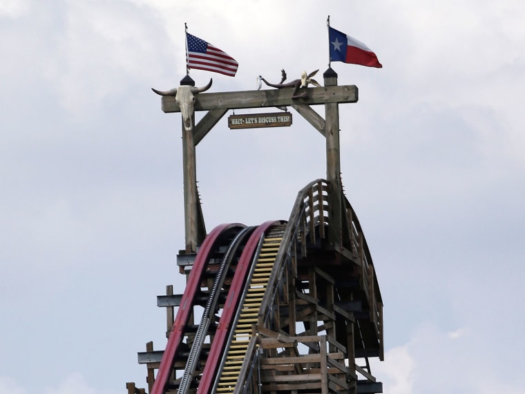 The Texas Giant roller coaster ride sits idle at the Six Flags Over Texas park Saturday, July 20, 2013, in Arlington, Texas. Investigators will try to determine if a woman who died while riding the roller coaster at the amusement park Friday night fell...
