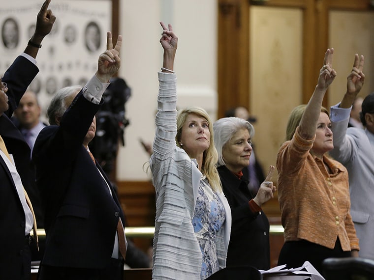 Sen. Wendy Davis, D-Fort Worth, center, holds up two fingers to signal a no vote as the session where they tried to filibuster an abortion bill draws to a close, Tuesday, June 25, 2013, in Austin, Texas.   (Photo by Eric Gay/AP)