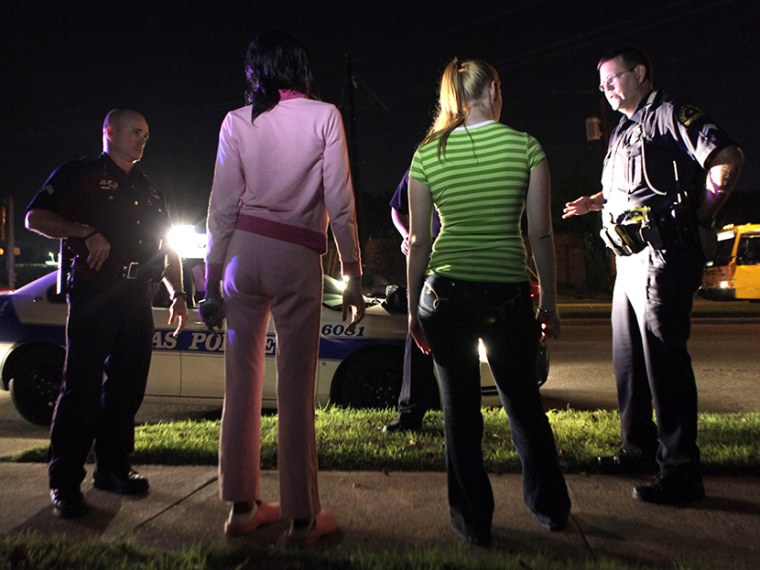 File Photo: In this Nov. 4, 2009 file photo, police talk to two young women before arresting them for prostitution in Dallas. The young woman second from left turned out to be underage at the time of her arrest. (Photo by LM Otero/AP)