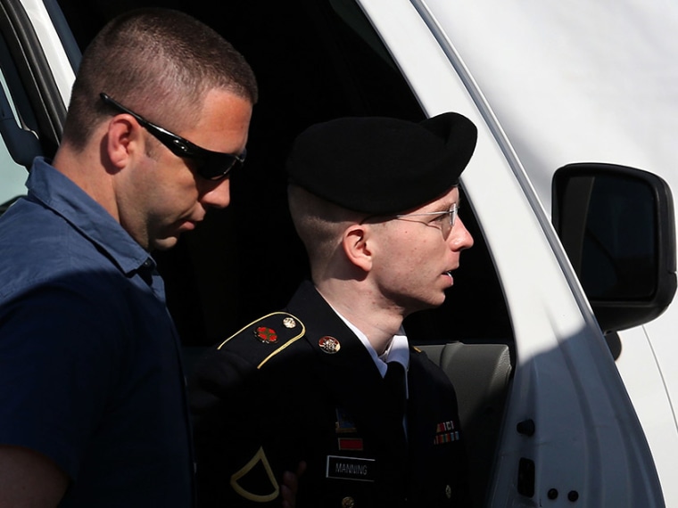 U.S. Army Private First Class Bradley Manning (R) is escorted by military police as arrives to hear the verdict in his military trial July 30, 2013, at Fort George G. Meade, Maryland.  (Photo by Mark Wilson/Getty Images)