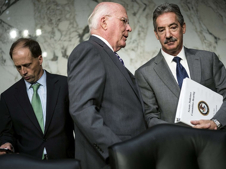 Committee chairman Sen. Patrick Leahy (C) speaks with Deputy Attorney General James Cole (R) after testimony from the first panel of witnesses during a hearing of the Senate Judiciary Committee on Capitol Hill July 31, 2013 in Washington, D.C.  (Photo...
