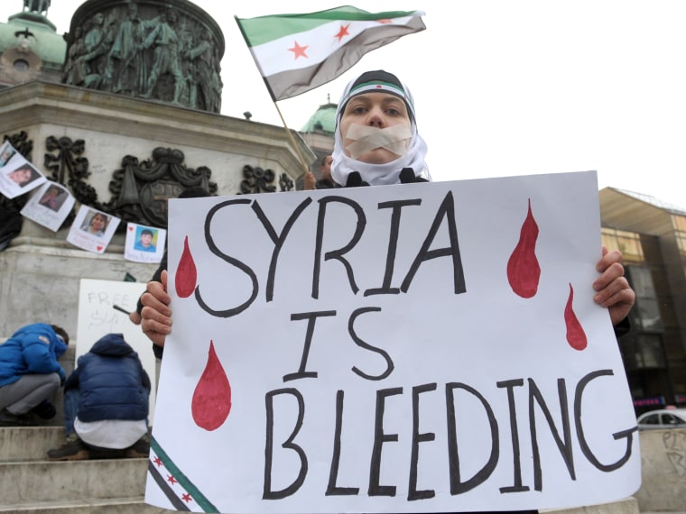 A Syrian living in Serbia displays a placard on March 16, 2013 during a protest against Syria's President Bashar al-Assad in the center of Belgrade.  (Photo by Alexa Sankovic/AFP/Getty Images)