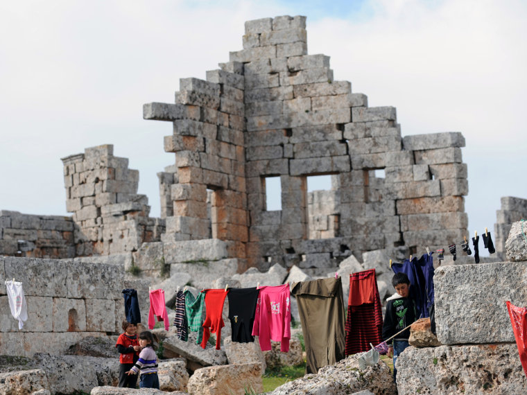Syrian refugees hang out their clothes to dry in the ruins of the ancient Roman city of of Serjilla, in the northwestern province of Idlib, on March 19, 2013. The conflict has killed at least 70,000 people, and forced more than one million Syrians to...