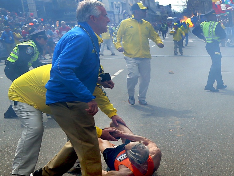 A second explosion goes off (rear) as a runner was blown to the ground by the first explosion near the finish line of the 117th Boston Marathon. (Photo by John Tlumacki/The Boston Globe via Getty Images)